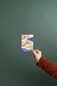 Ankerwechsel-Verlag-Shop: Amsteram Postkarte – Illustriert von Saskia Rasink vor grünem Hintergrund mit Hand