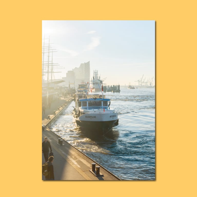 Fotodruck mit einer Barkasse an den Landungsbrücken im Hamburger Hafen bei Morgenlicht