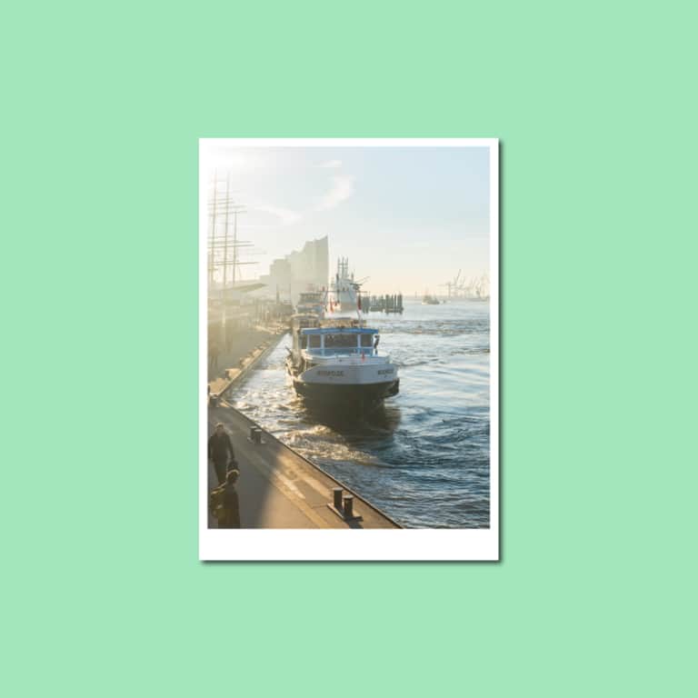 Postkarte mit einer Barkasse an den Landungsbrücken im Hamburger Hafen bei Morgenlicht